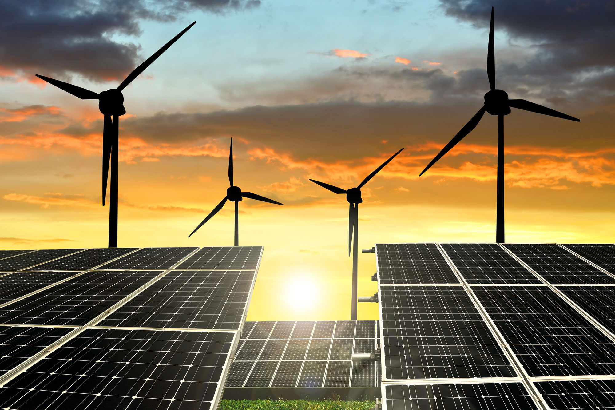 solar panels and wind generators at sunset